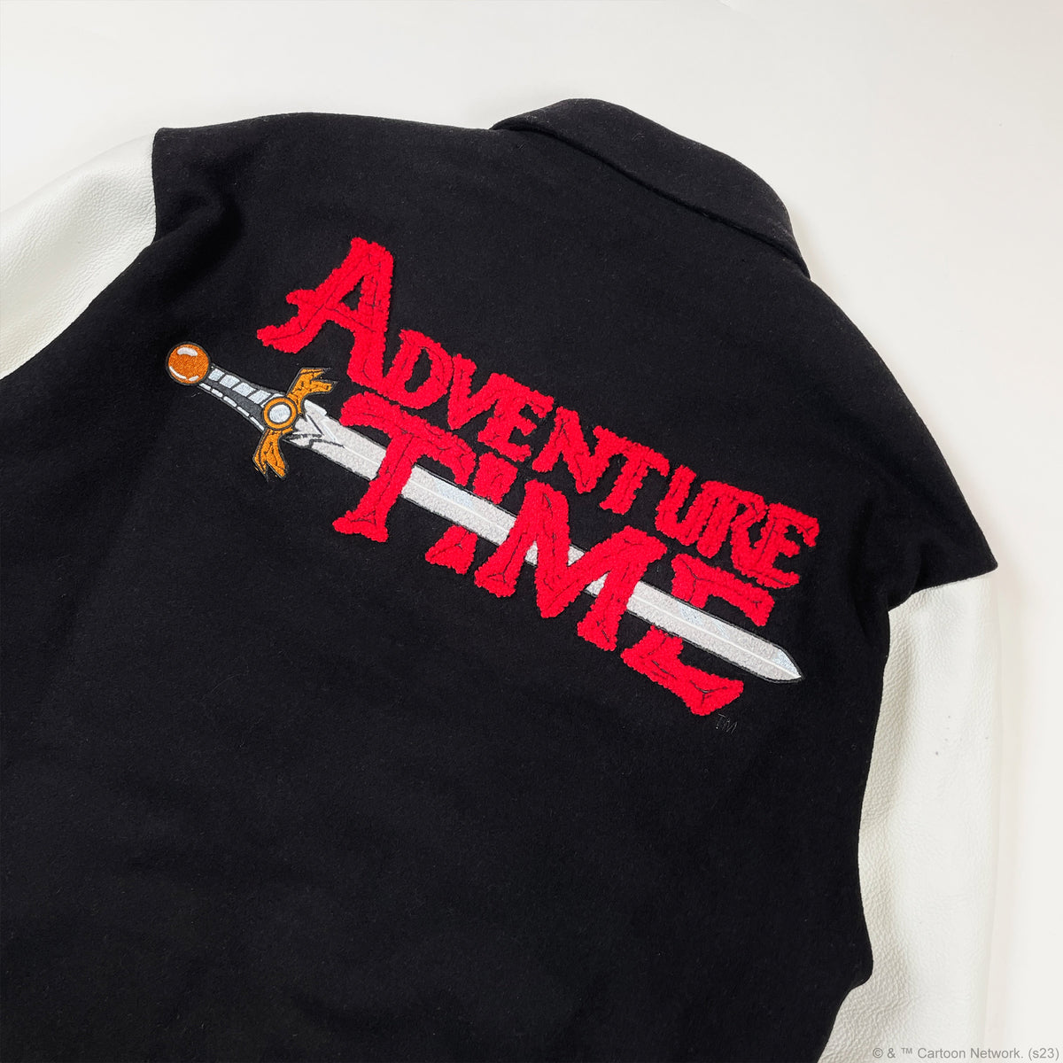 Close-up of the oversized red Adventure Time chenille logo and embroidered sword across the jacket back