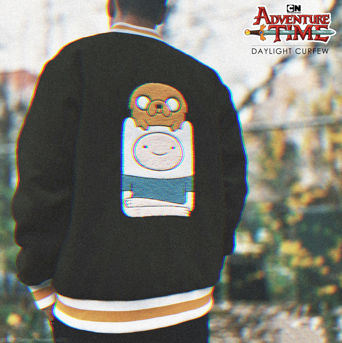 Original Black varsity jacket worn outdoors, cropped to highlight Finn and Jake back artwork